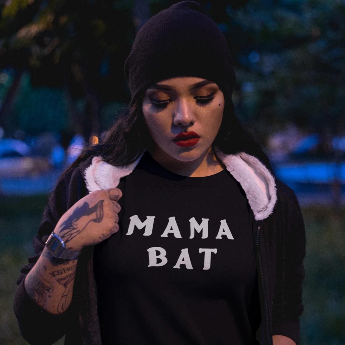 A woman wearing the Mama Bat tee outside at dusk